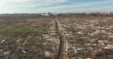 Two people walking on a huge aste, garbade, dump, rubbish landill in Bucharest Video stock 198213883
