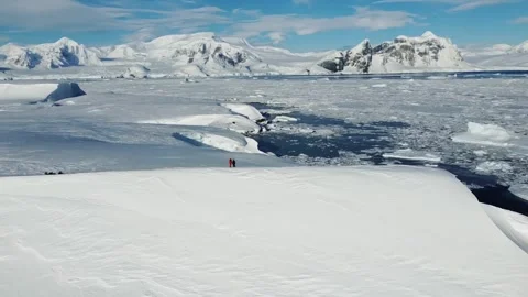 Two people walking on icy cliff in Antarctica, aerial drone view in winter Stock-Footage 328322253