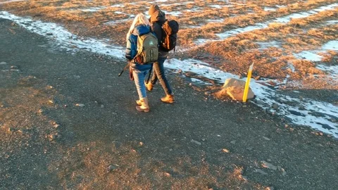 Two people walking lonely path in winter during sunset Stock Footage 107883274