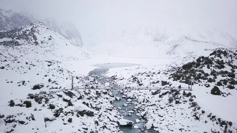 Two people walking over bridge with foggy mountains in background, New Zealand Stock Footage 121599008