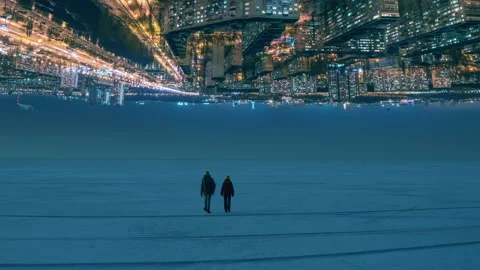 The two people walking through the night snow field on the citylights background Stock Footage 189417390