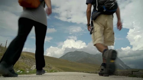 Two People Walking In A Valley Towards The Mountain Video stock 207669530