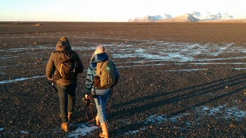 Two people walking winter during golden hour landscape - drone shot Stock Footage 107883165