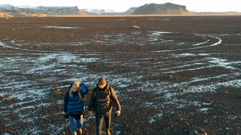 Two people walking winter during golden hour landscape - drone long shot Stock Footage 107883745