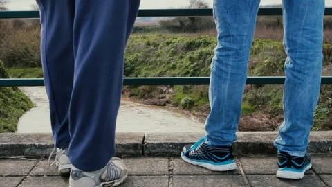 Two people watching the river in a brigde and then walk away Stock Footage 108099321