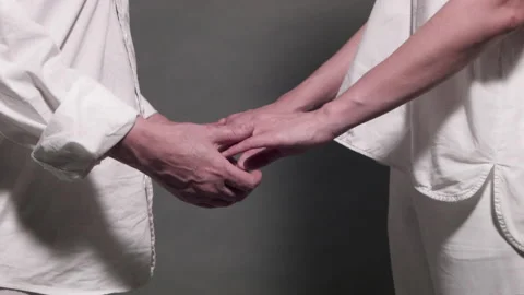 Two People In White Clothes Holding Hands Stock Footage 169934503