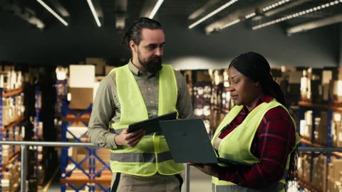 Two people working together on parcel tracking in industrial warehouse Stock Footage 330207359