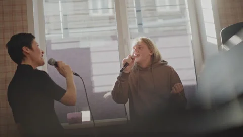 Two performers sing collaboratively in training. Two vocalists harmonize in Vídeos de archivo 347523281