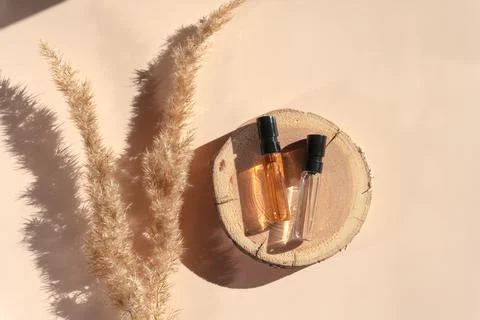 Two perfume testers with transparent liquid on a woodcut with pampas grass on Stock Photos