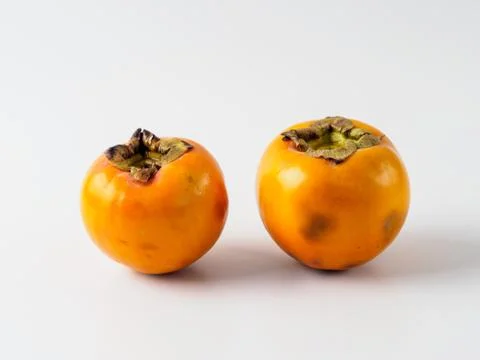 Two persimmon isolated on white background. Stock Photos