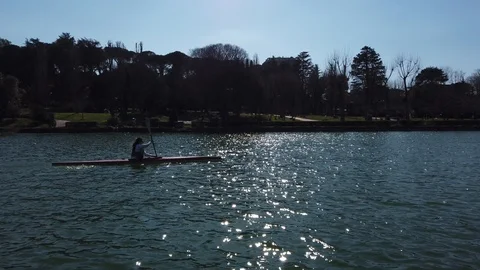 Two person with canoe with reflections on the water. Laghetto Eur. Rome. Video stock 125285489