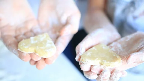 Two person hold in hands Gingerbread cookies with the shape of heart. Closeup Stock Footage 100077377