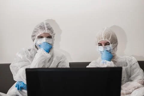 Two person in protective white translucent suit, blue rubber gloves, medical Stock Photos