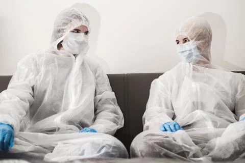 Two person in protective white translucent suit, blue rubber gloves, medical Stock Photos