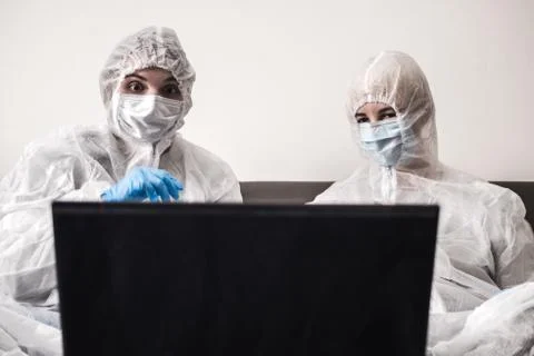 Two person in protective white translucent suit, blue rubber gloves, medical Stock Photos