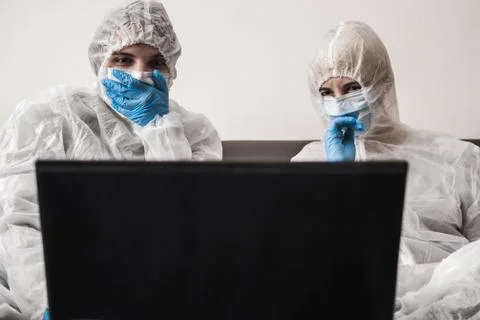 Two person in protective white translucent suit, blue rubber gloves, medical Stock Photos