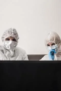 Two person in protective white translucent suit, blue rubber gloves, medical Stock Photos