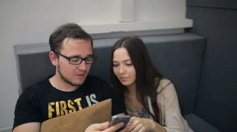 Two person sit on sofa in studio and play with smartphone Stock Footage 67185838