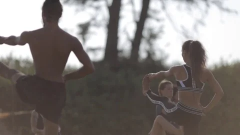 Two persons doing couple yoga namaste pose on the beach at sunset Stock Footage 73917996