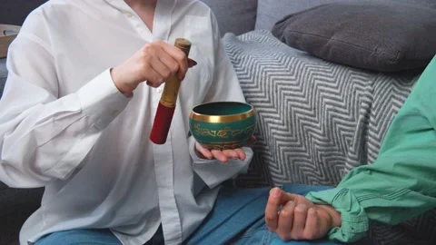 Two persons doing meditation or yoga at home. Using tibetan singing bowl. Modern Stock Footage 167389353