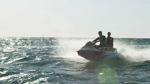 Two persons in life jackets are moving on jet ski in the sun. tourists are Stock Footage 201345111