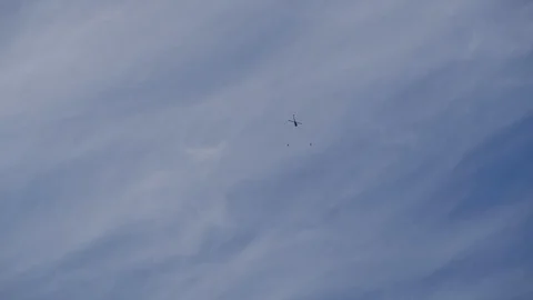 Two persons parachuting out of an helicopter with a blue cloudy sky. Stock Footage 111851625