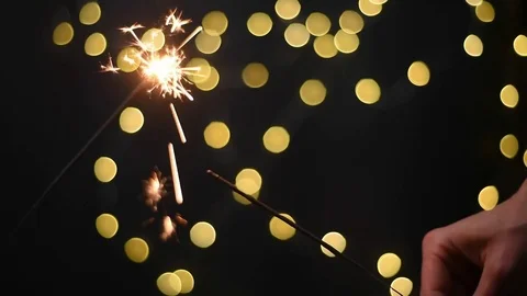 Two persons plays with  lighting sparklers on dark backround Stock Footage 83143924