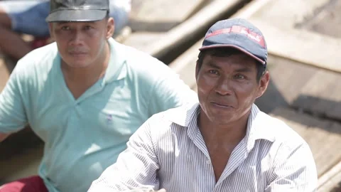 Two Peruvian men are smile in a wooden boat. call tourists to go with them  Stock-Footage 233288450