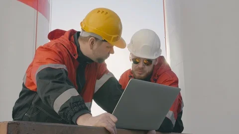 Two petrochemical engineers discuss data on laptop screen. Stock Footage 109532309