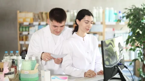 Two pharmacists employee using computer Stock Footage 331312244