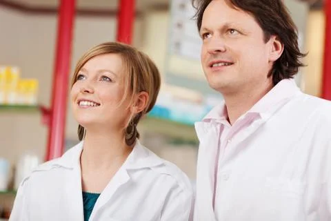 Two pharmacists looking up Stock Photos