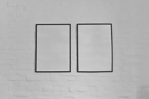 Two photo frames with copy space hanging on white bricks wall, interior dec.. Stock Photos
