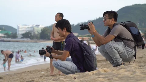Two photographers doing a photo session on the beach. A group of girlfriends  Stock Footage 102308455