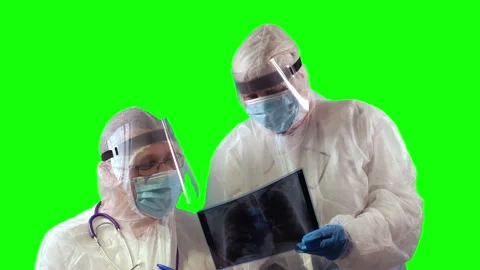 Two physicians in PPE suit uniforms, wearing medical protective masks and face Stock Footage 148292107