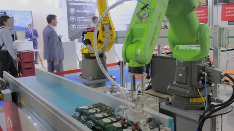 Two pick and place robotic arm manipulators moving grains packages at exhibition Vidéo 162137949