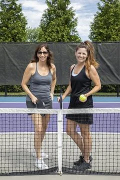 Two pickleball players posing at the net Stock Photos