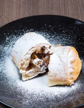 Two pieces of apple strudel on a black plate Stock Photos