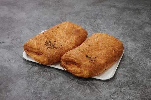 Two pieces of bread with cheese and herbs on top Stock Photos