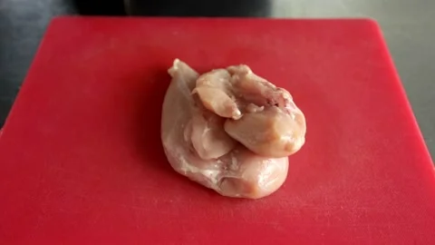 Two pieces of chicken breast meat for cooking steak falls onto a butcher board. Stock Footage 159155815