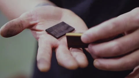 Two pieces of ebony in a man's hand. handmade carpentry. the sound of carpent Stock Footage 146572154