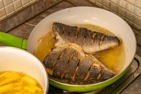 Two pieces of fresh fish fried in a pan, healthy food, Stock Photos