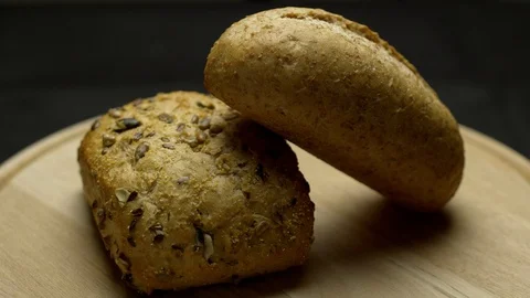 Two pieces of integral bread on a wooden board Stock Footage 106753733