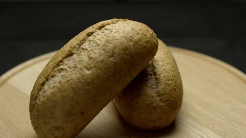 Two pieces of integral bread on a wooden board Stock Footage 106753821