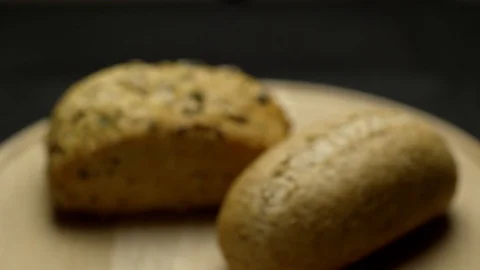 Two pieces of integral bread on a wooden board Stock Footage 106753950