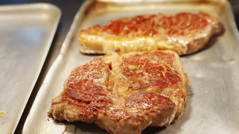 Two pieces of meat are on a pan Stock Footage 296056755