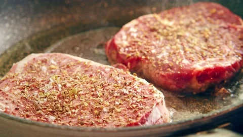 Two Pieces of spiced raw steak are pan-fried at home. Stock Footage 160184732