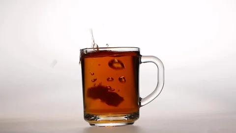 Two pieces of sugar are thrown into cup hot tea, slow motion Stock Footage 73854724