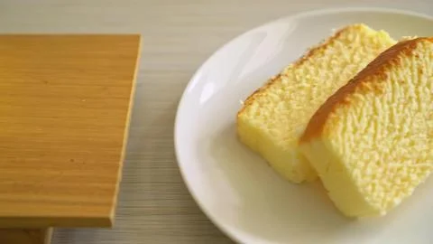 Two pieces of yellow sponge cake on a white plate Stock Photos