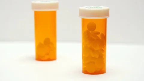 Two pill bottles sit on white counter. Stock Footage 108033381