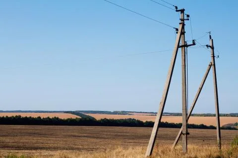 Two pillars of power lines on a background of autumn hills and stubble, selec Stock Photos